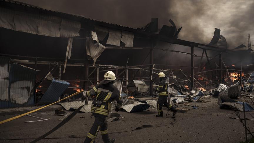 Des pompiers tentent d’éteindre un incendie dans un entrepôt au milieu des bombardements russes à Kharkiv, en Ukraine.