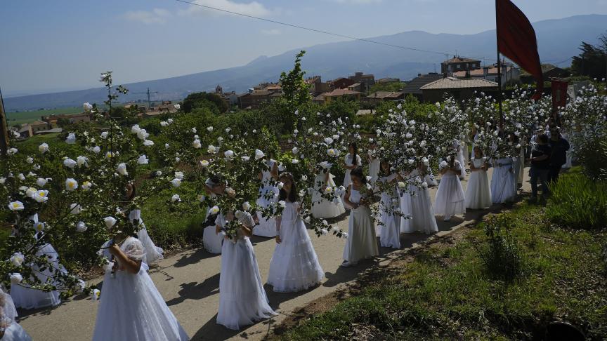 Des jeunes filles vêtues de blanc et entourées de fleurs, participent au pèlerinage pour honorer le printemps et la fertilité des femmes en Espagne.