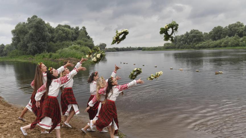 Des femmes biélorusses en costumes nationaux jettent des couronnes dans l'eau de la rivière Bérézina le jour d'Ivan Kupala, marquant le solstice d'été.