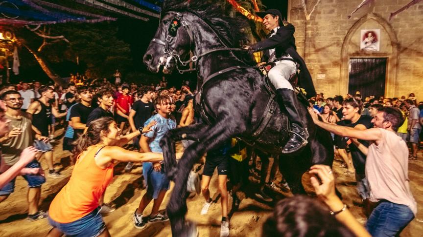 Un cavalier se dresse sur son cheval entouré d'une foule en liesse pendant le traditionnel «Jaleo» aux îles Baléares.