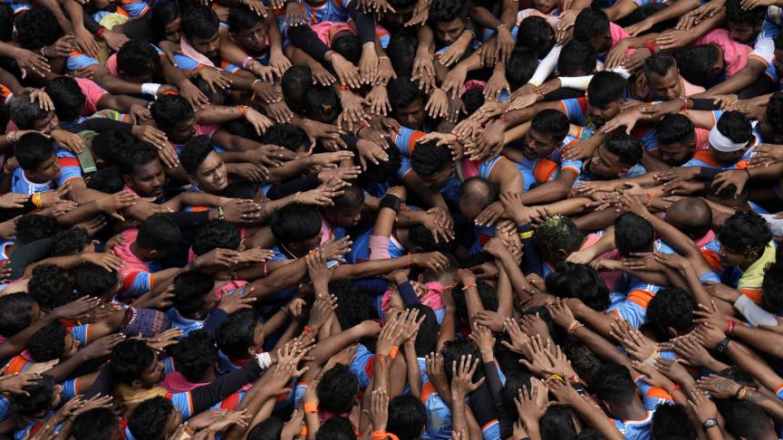 Les gens prient avant de former une pyramide humaine pour le festival Janmashtami à Mumbai, en Inde.