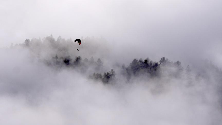 Un parapente s'envole dans les airs au-dessus des arbres près du glacier de Stubai dans le Tyrol, en Autriche.