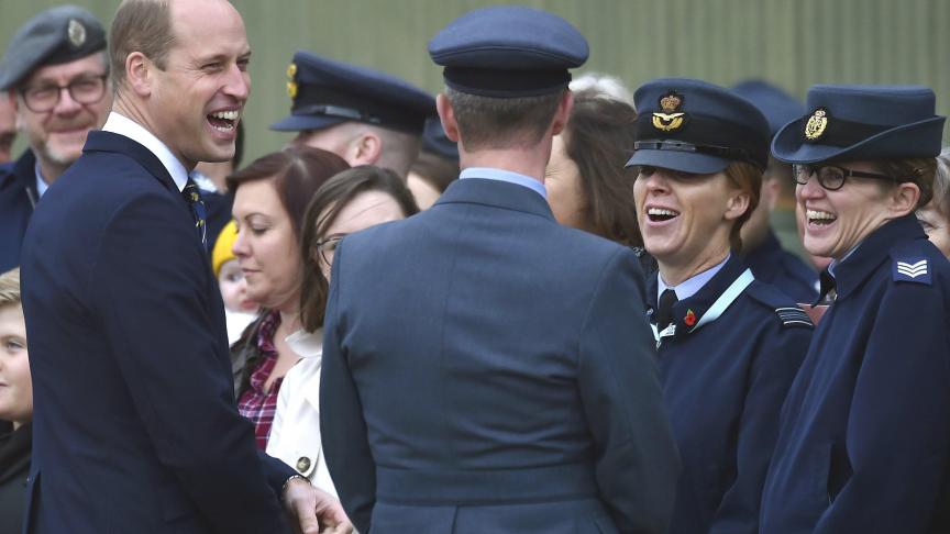 Le Prince William qui sourit en rencontrant des familles de la Royal Air Force lors d’une visite à la base de Coningsby pour s'informer des futures innovations technologiques.