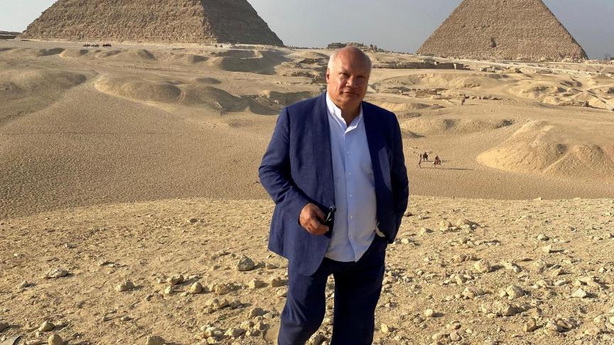 Éric-Emmanuel Schmitt pose en octobre dernier devant les pyramides de Gizeh, vestiges de l’Égypte ancienne.