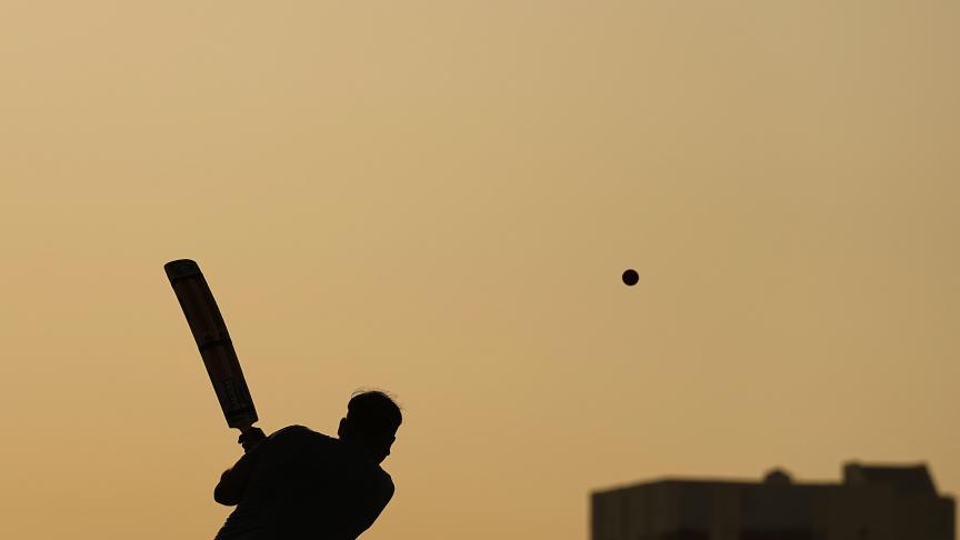 Des gens jouent au cricket dans les rues de Doha, au Qatar.