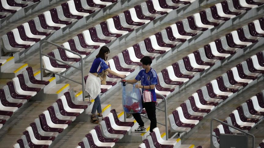 Des supporters du Japon qui ramassent des déchets après le match entre le Japon et l'Espagne, au stade international Khalifa à Doha, Qatar.