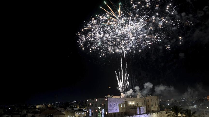 Des feux d'artifice illuminent la vieille ville de Jérusalem, lors d'une cérémonie marquant l'illumination de l'arbre de Noël, le dimanche 11 décembre 2022.