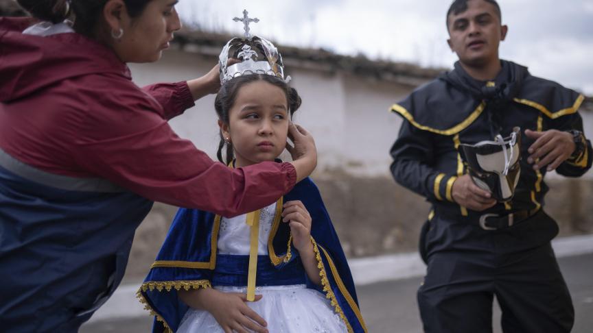 Une femme place une couronne sur la tête de sa fille âgée de 7 ans et habillée en Vierge de l'Immaculée Conception, lors de la «La quema del diablo» au Guatemala.