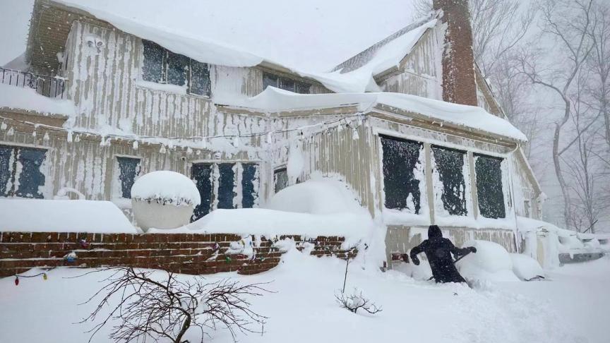 Un habitant enlève la neige d'un bâtiment à Amherst, dans le comté d'Erie, dans l'État de New York, aux États-Unis, le 24 décembre 2022.