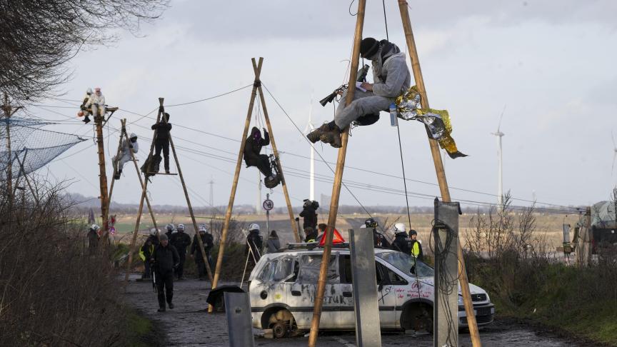 Des militants pour le climat sont assis dans des «tripos» et bloquent une route dans le village de Luetzerath près d'Erkelenz, en Allemagne, mercredi 11 janvier 2023.