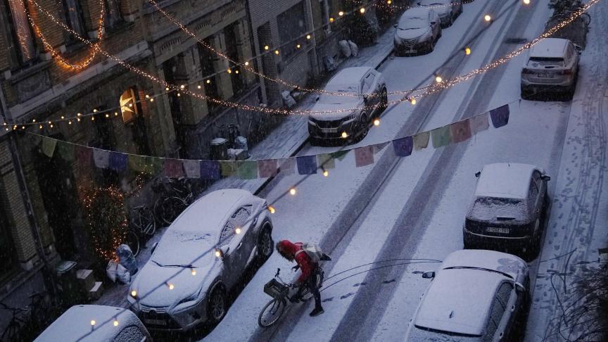 Un élève se rendant à l'école se prépare lors de la première chute de neige de la saison à Anvers, en Belgique.