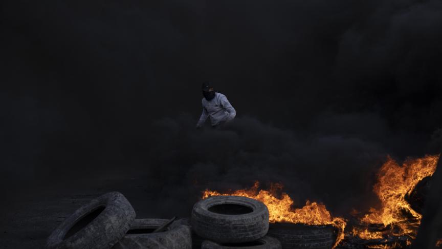 Des manifestants palestiniens bloquent la route principale avec des pneus en feu dans la ville de Jéricho, en Cisjordanie.