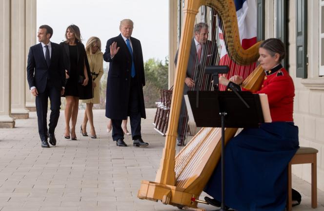 Une harpiste en costume traditionnel joue devant les couples Trump et Macron.